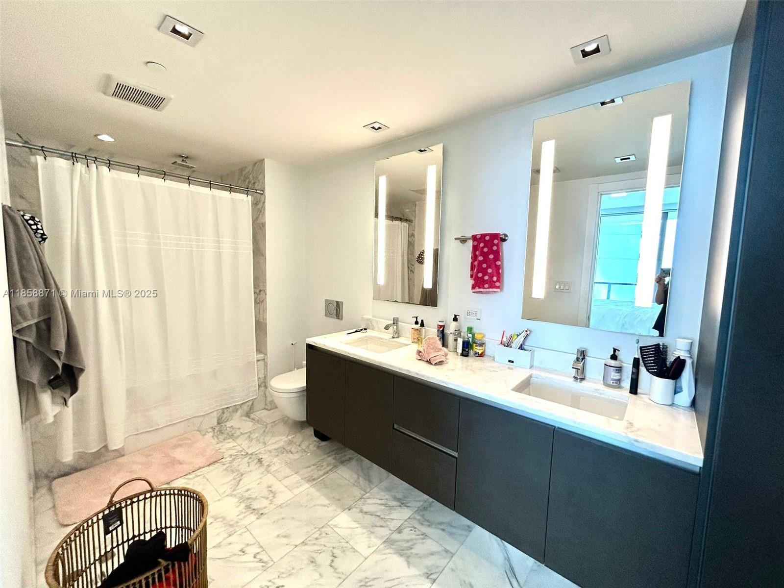 1451 Brickell Avenue, Unit 2102 Miami, FL 33131 - Photo 10 of 14 a bathroom with a double vanity sink and mirror