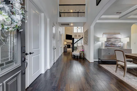 a dining room with wooden floor a glass table and chairs