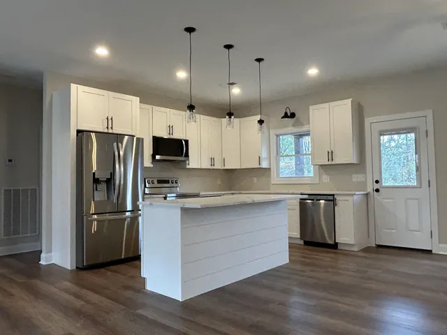 a kitchen with granite countertop a refrigerator and a sink