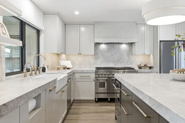 a large kitchen with stainless steel appliances kitchen island a large counter top and a wooden floors