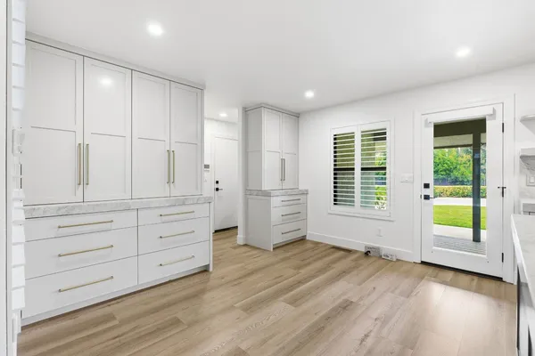 a living room with furniture two window and wooden floor