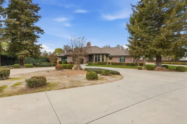a view of swimming pool with outdoor seating and house in the background