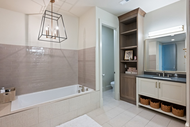 3 Carriagewood Cove, Unit 1088 Sandy, UT 84092 - Photo 60 of 79 Bathroom featuring a built-in soaking tub, subway tile wainscoting, and a geometric chandelier