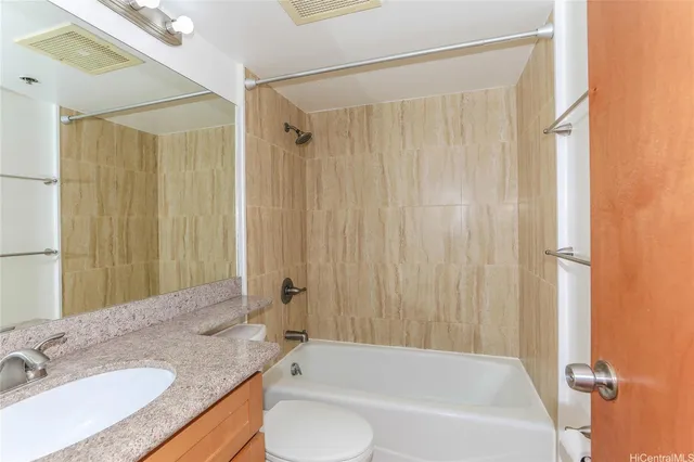 a bathroom with a granite countertop sink and a bathtub