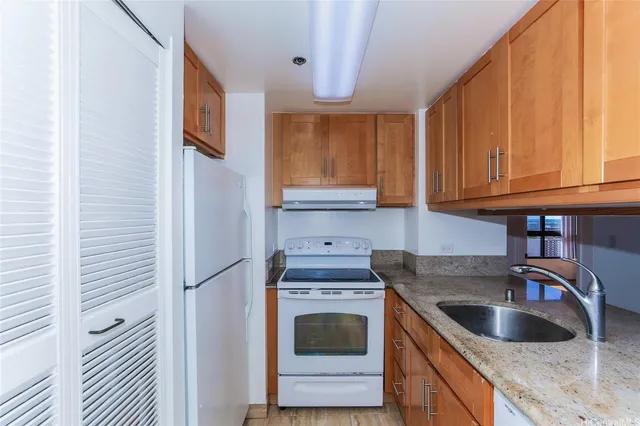 a kitchen with granite countertop a sink and a stove top oven