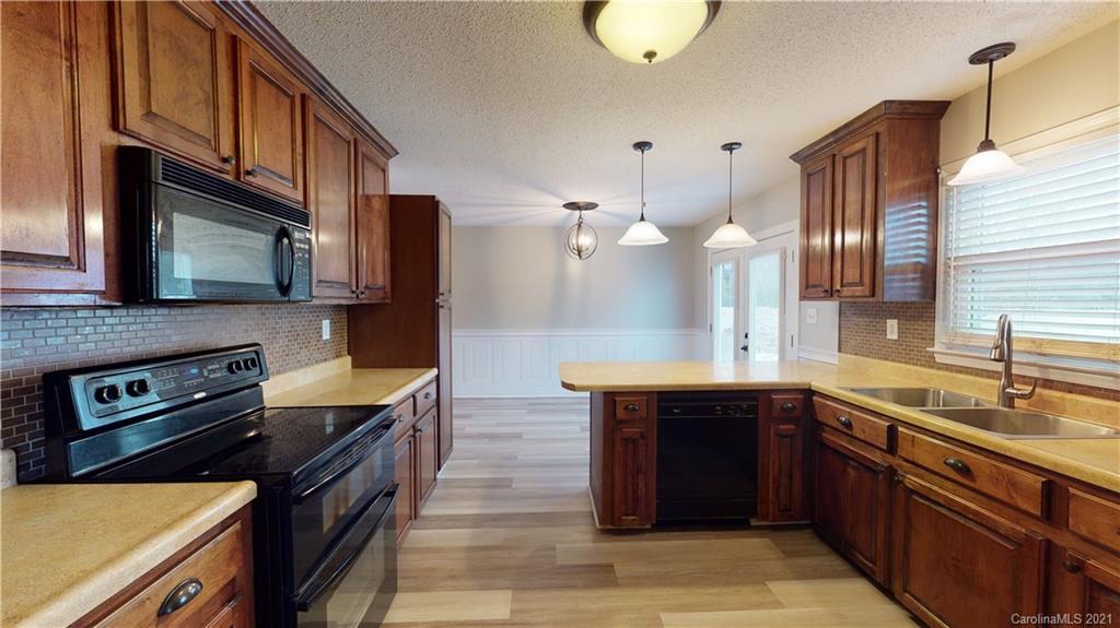 960 George Brown Road Crouse, NC 28033 - Photo 11 of 31 a kitchen with stainless steel appliances granite countertop a sink wooden cabinets and stove