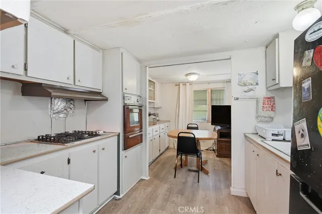 a kitchen with stainless steel appliances kitchen island granite countertop a refrigerator and wooden cabinets