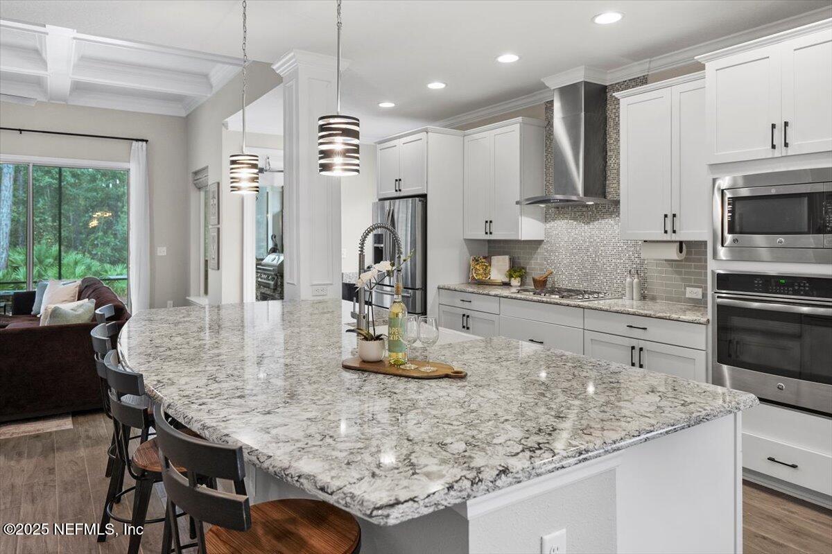 174 Beartooth Trail Ponte Vedra, FL 32081 - Photo 10 of 29 a kitchen with kitchen island granite countertop a table chairs microwave and cabinets
