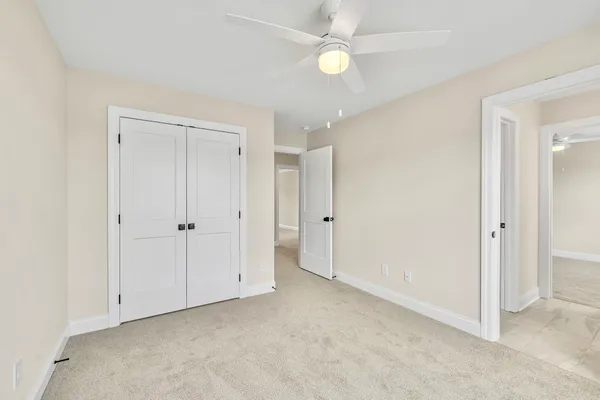 a view of an empty room with a ceiling fan