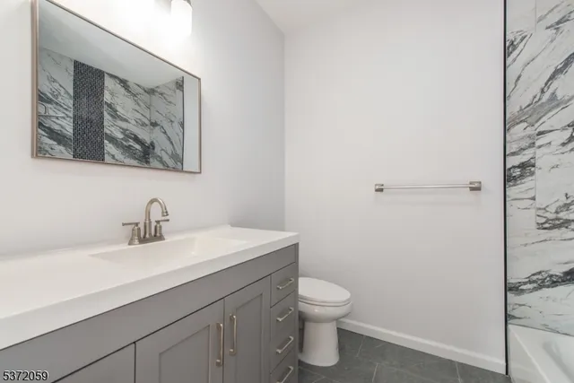 a bathroom with a toilet a sink and mirror