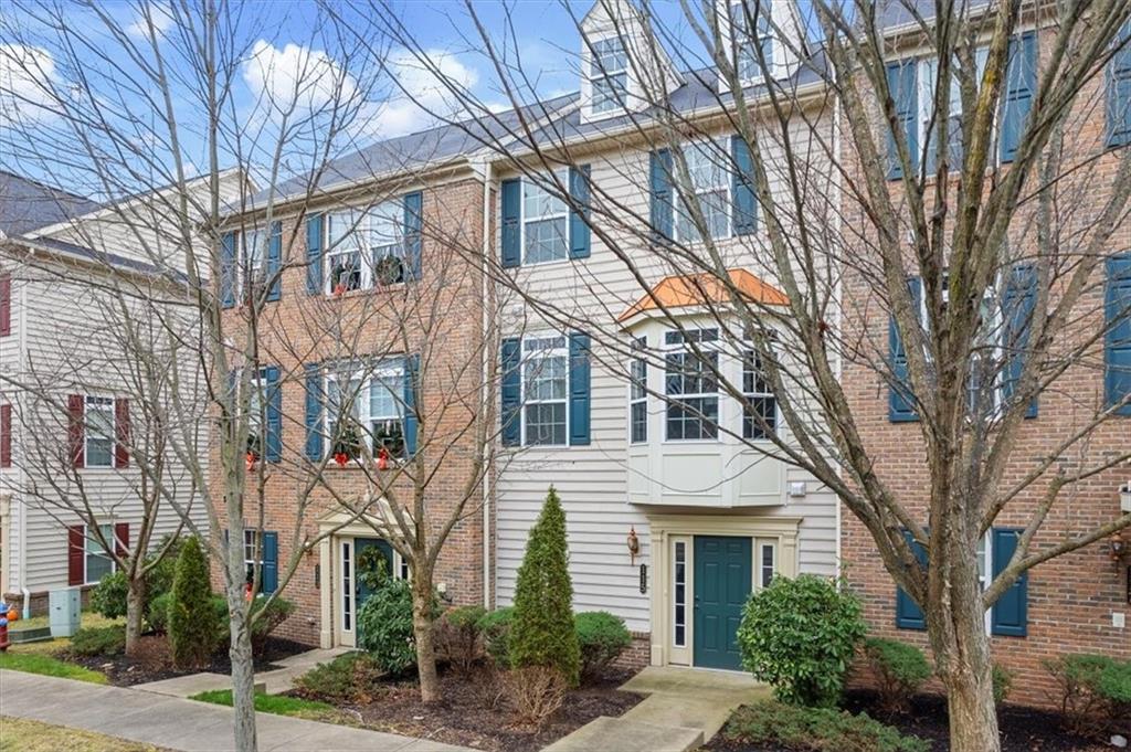 a front view of a residential houses with yard and trees