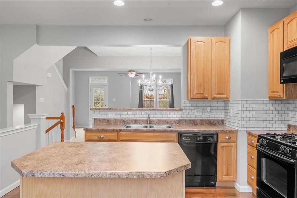 115 Lewisham Road Cranberry Township, PA 16066 - Photo 9 of 38 a kitchen with granite countertop a sink a stove and a wooden floors