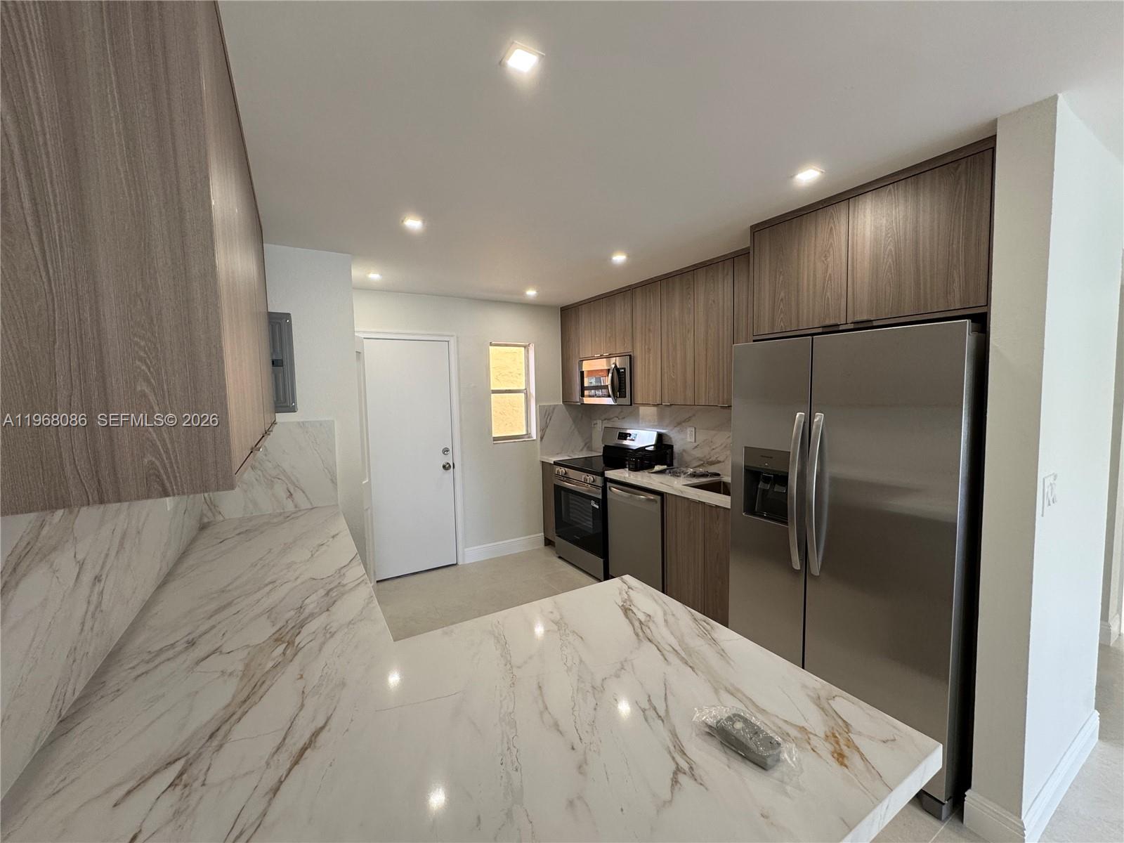 1900 West 54th Street, Unit 219 Hialeah, FL 33012 - Photo 1 of 42 a kitchen with granite countertop a refrigerator and a sink