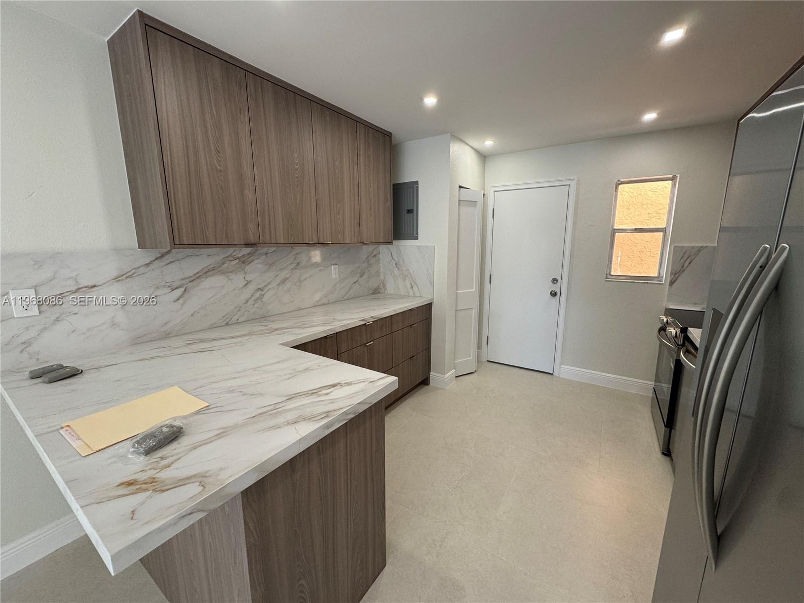 1900 West 54th Street, Unit 219 Hialeah, FL 33012 - Photo 12 of 42 a view of kitchen cabinets and refrigerator