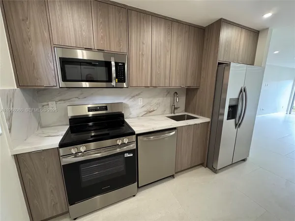 a kitchen with stainless steel appliances a stove a microwave a sink and cabinets