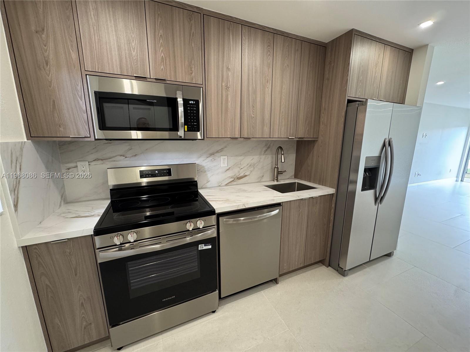 1900 West 54th Street, Unit 219 Hialeah, FL 33012 - Photo 3 of 42 a kitchen with stainless steel appliances a stove a microwave a sink and cabinets