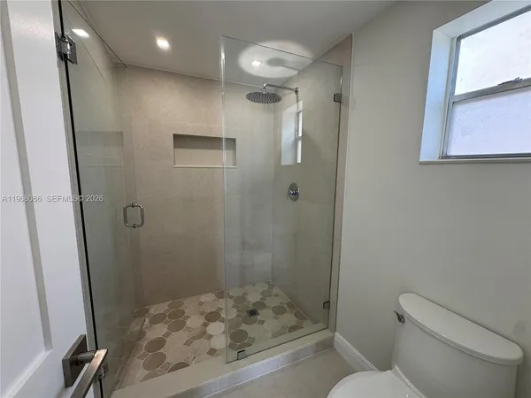 a bathroom with a shower toilet and sink