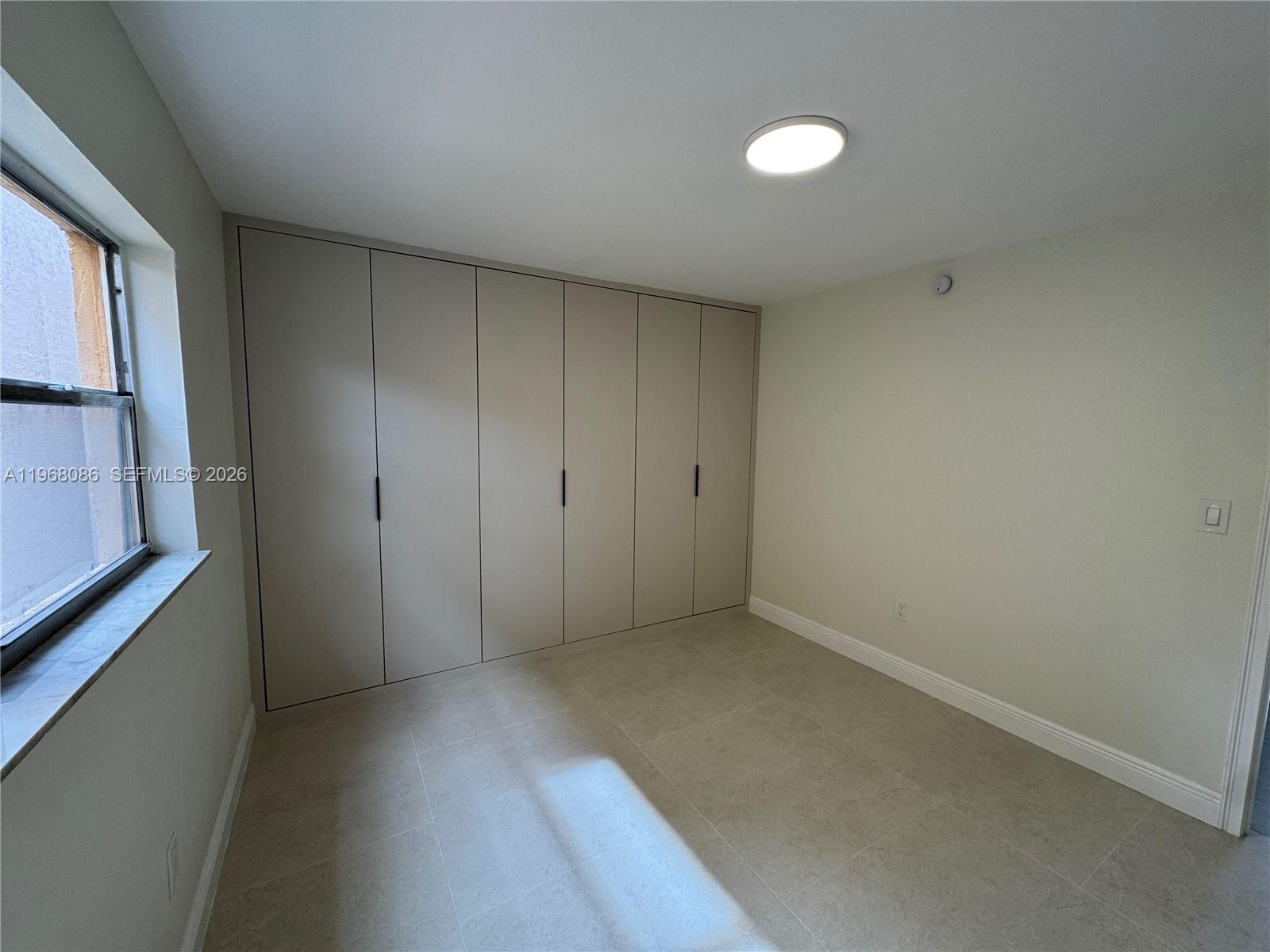 1900 West 54th Street, Unit 219 Hialeah, FL 33012 - Photo 6 of 42 a view of an empty room with a window