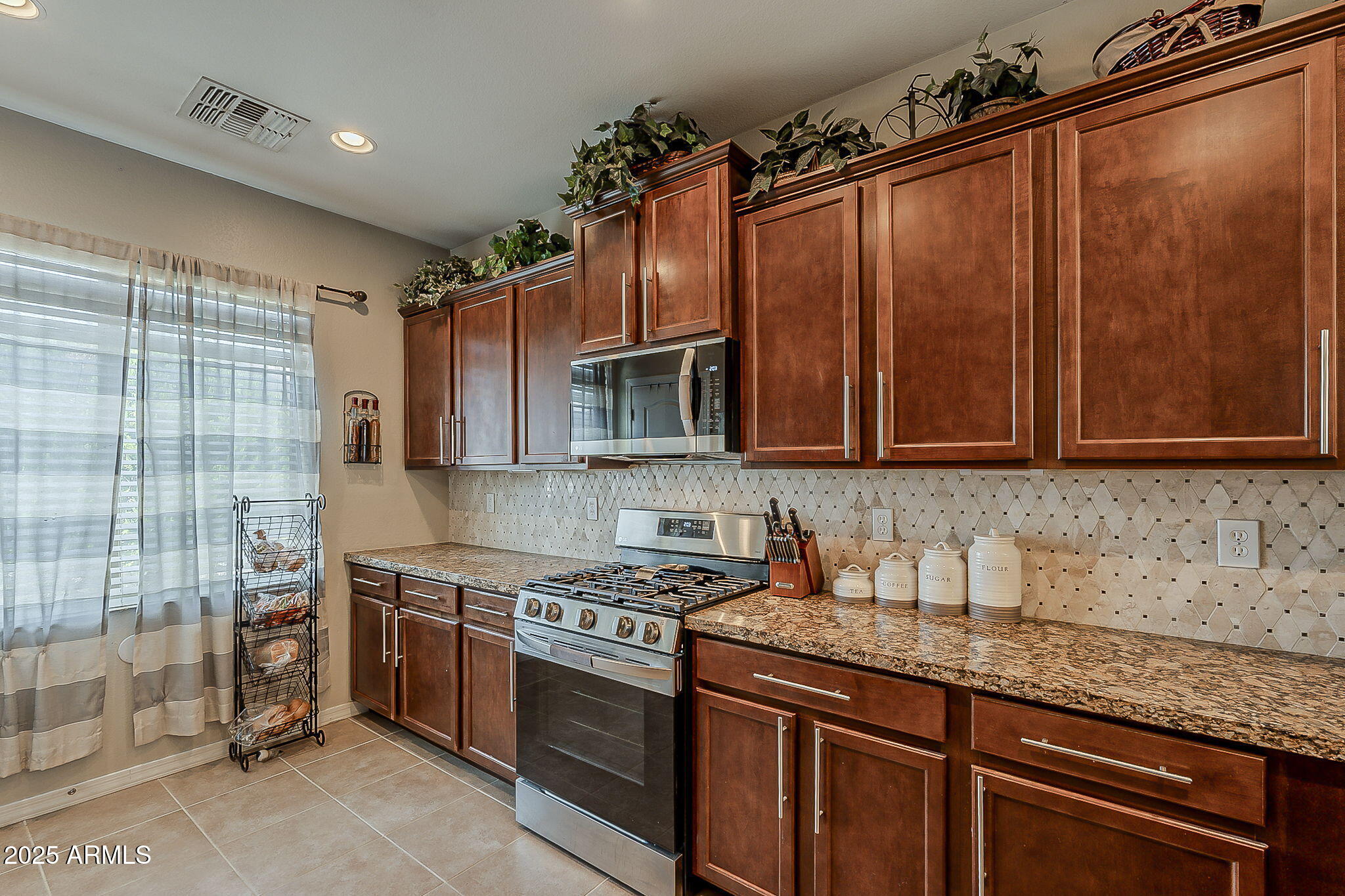 4407 West Crescent Road San Tan Valley, AZ 85144 - Photo 12 of 50 a kitchen with stainless steel appliances granite countertop a sink stove and cabinets