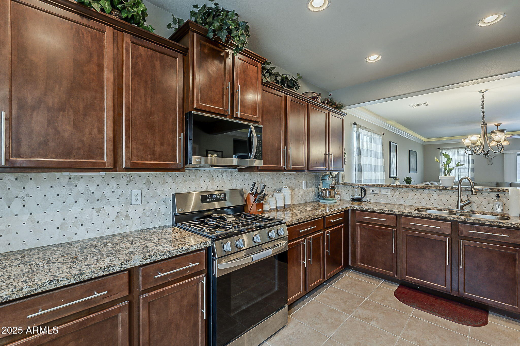 4407 West Crescent Road San Tan Valley, AZ 85144 - Photo 10 of 50 a kitchen with granite countertop stainless steel appliances a sink a stove top oven a counter space and cabinets