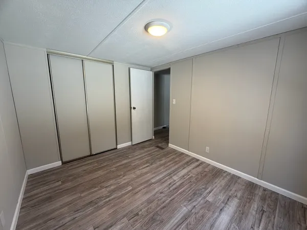 a view of an empty room with wooden floor