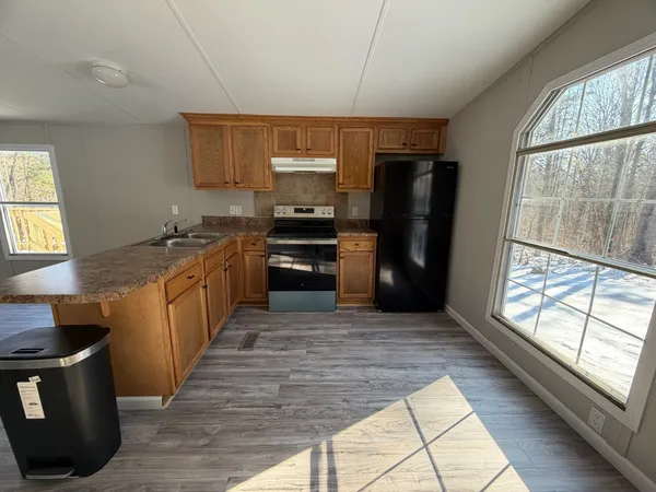 a large kitchen with stainless steel appliances granite countertop a stove a sink and a refrigerator