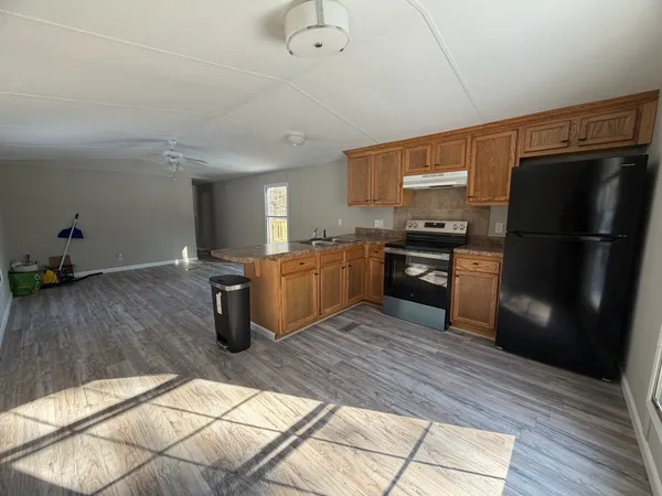 a kitchen with granite countertop a refrigerator stove top oven and sink