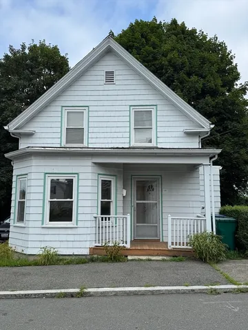 a front view of a house with garage and trees