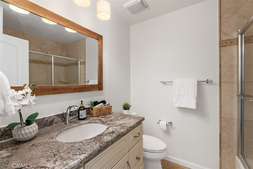 964 Lansing Lane Costa Mesa, CA 92626 - Photo 19 of 29 a bathroom with a granite countertop sink a toilet and a mirror