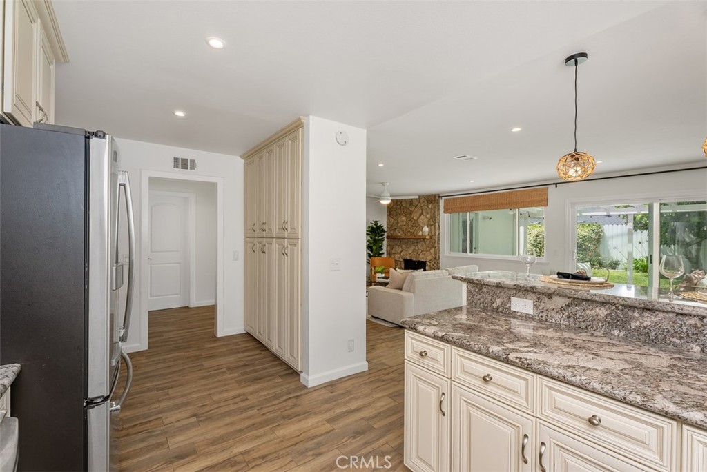 964 Lansing Lane Costa Mesa, CA 92626 - Photo 10 of 29 a kitchen with granite countertop kitchen island wooden floor center island and stainless steel appliances