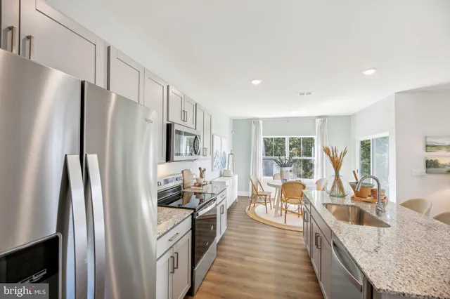 a kitchen with stainless steel appliances granite countertop a refrigerator stove and sink