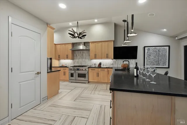 a kitchen with stainless steel appliances granite countertop a sink refrigerator and cabinets