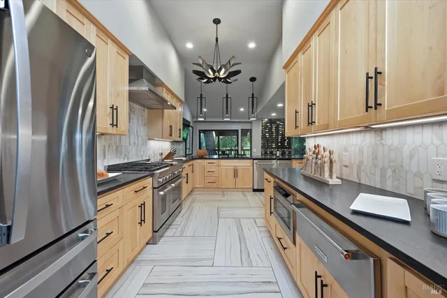 a kitchen with stainless steel appliances a sink stove and refrigerator