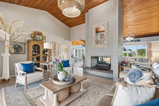 a living room with furniture a fireplace and a large window