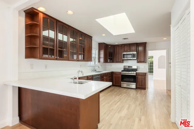 a kitchen with kitchen island a sink stainless steel appliances and cabinets