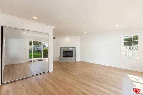 an empty room with wooden floor and a fireplace