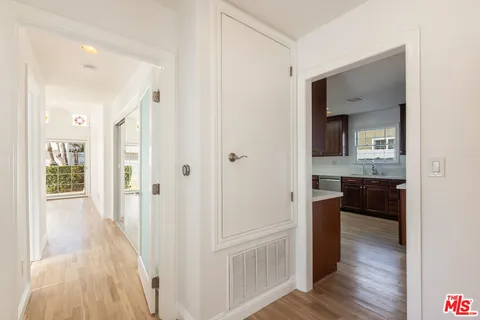 a view of a hallway with wooden floor and closet
