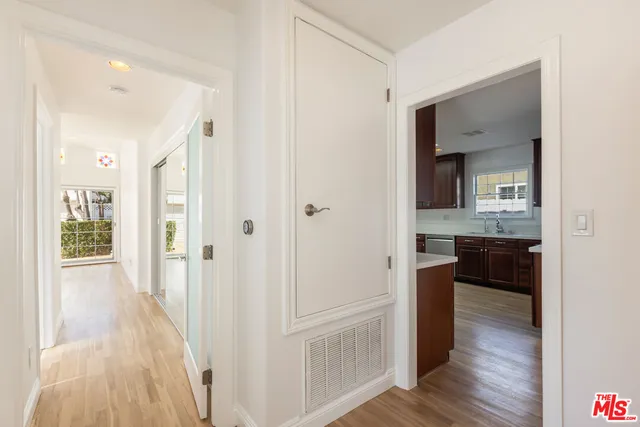 a view of a hallway with wooden floor and closet