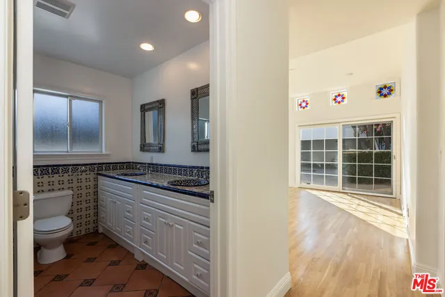 a bathroom with a toilet a sink and mirror