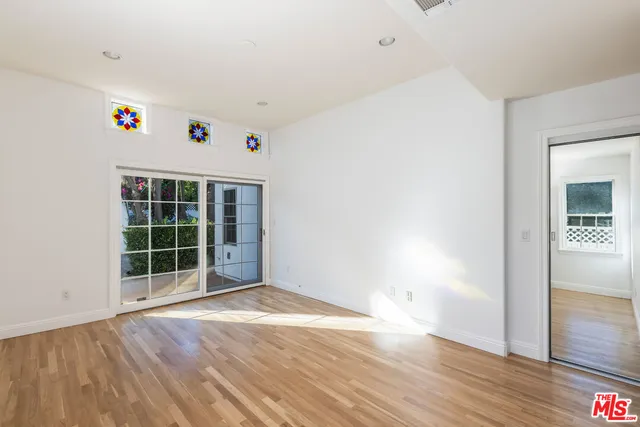 a view of hallway with window and wooden floor