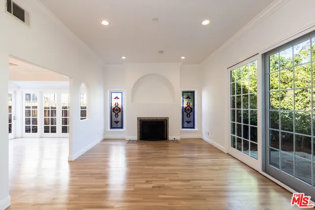 an empty room with wooden floor and a fireplace