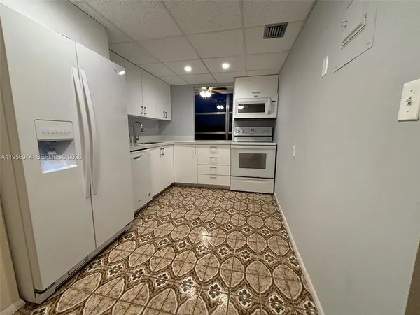 a kitchen with stainless steel appliances granite countertop a refrigerator and a stove top oven
