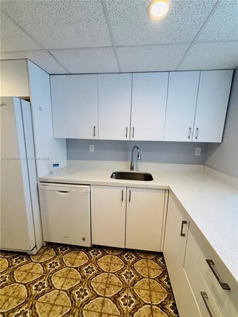 a kitchen with white cabinets and white appliances