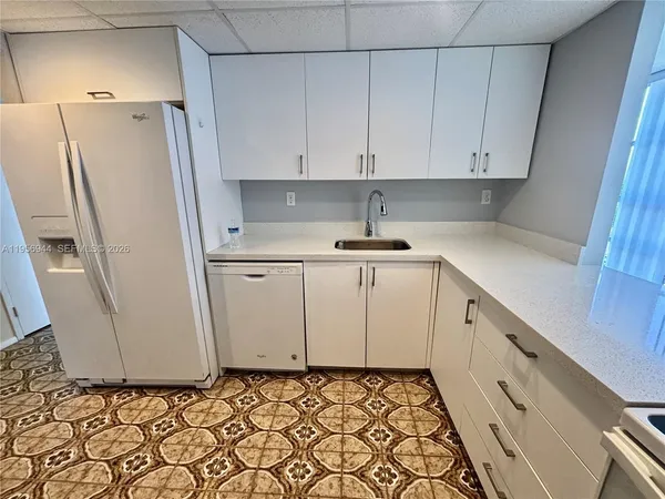 a kitchen with white cabinets and white appliances