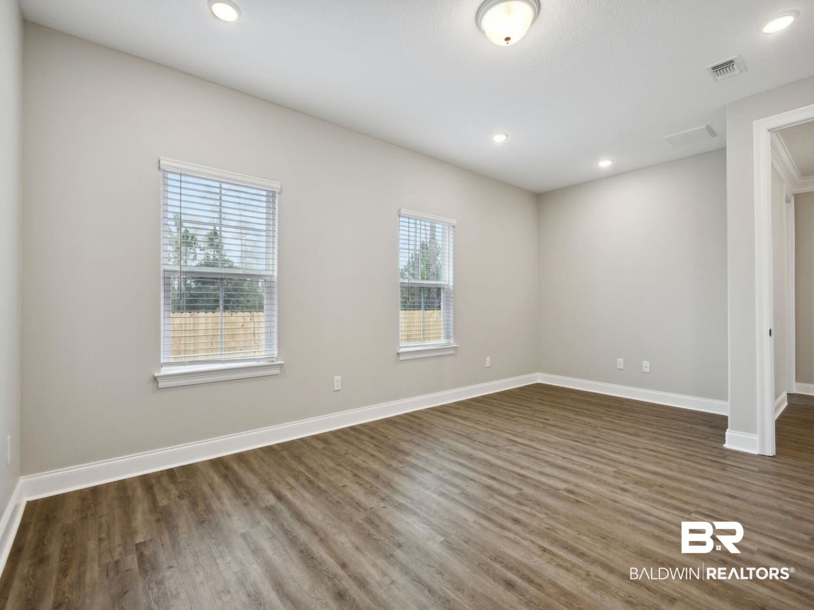 12942 Gondala Street Elberta, AL 36530 - Photo 9 of 18 Empty room featuring recessed lighting and dark wood-style flooring