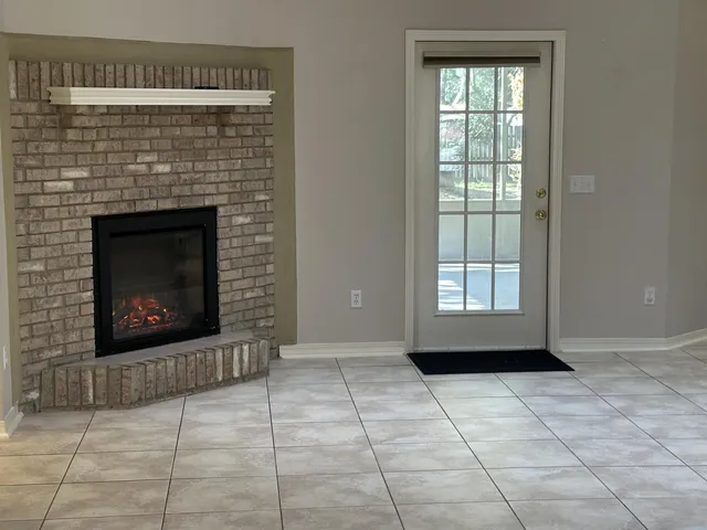 a view of an empty room with windows and fireplace
