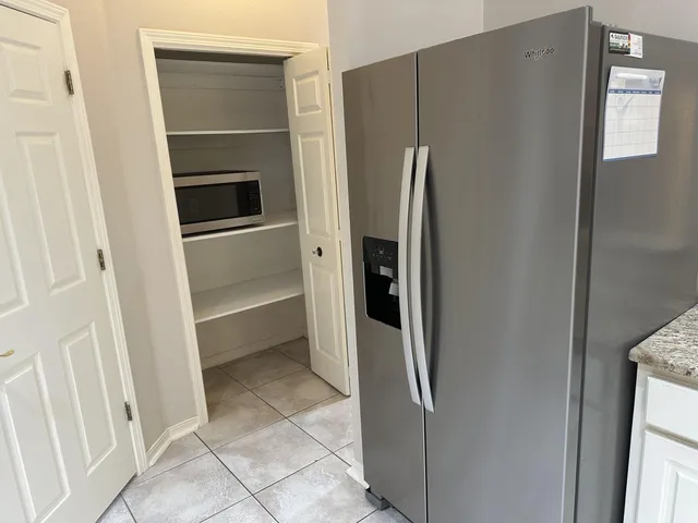 a kitchen with a refrigerator and microwave