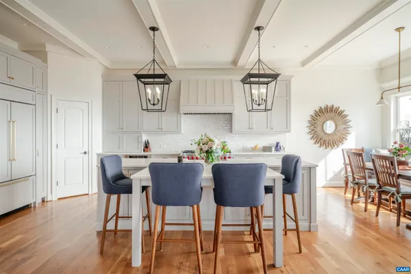 a kitchen with stainless steel appliances granite countertop a kitchen island hardwood floor sink stove dining table and chairs