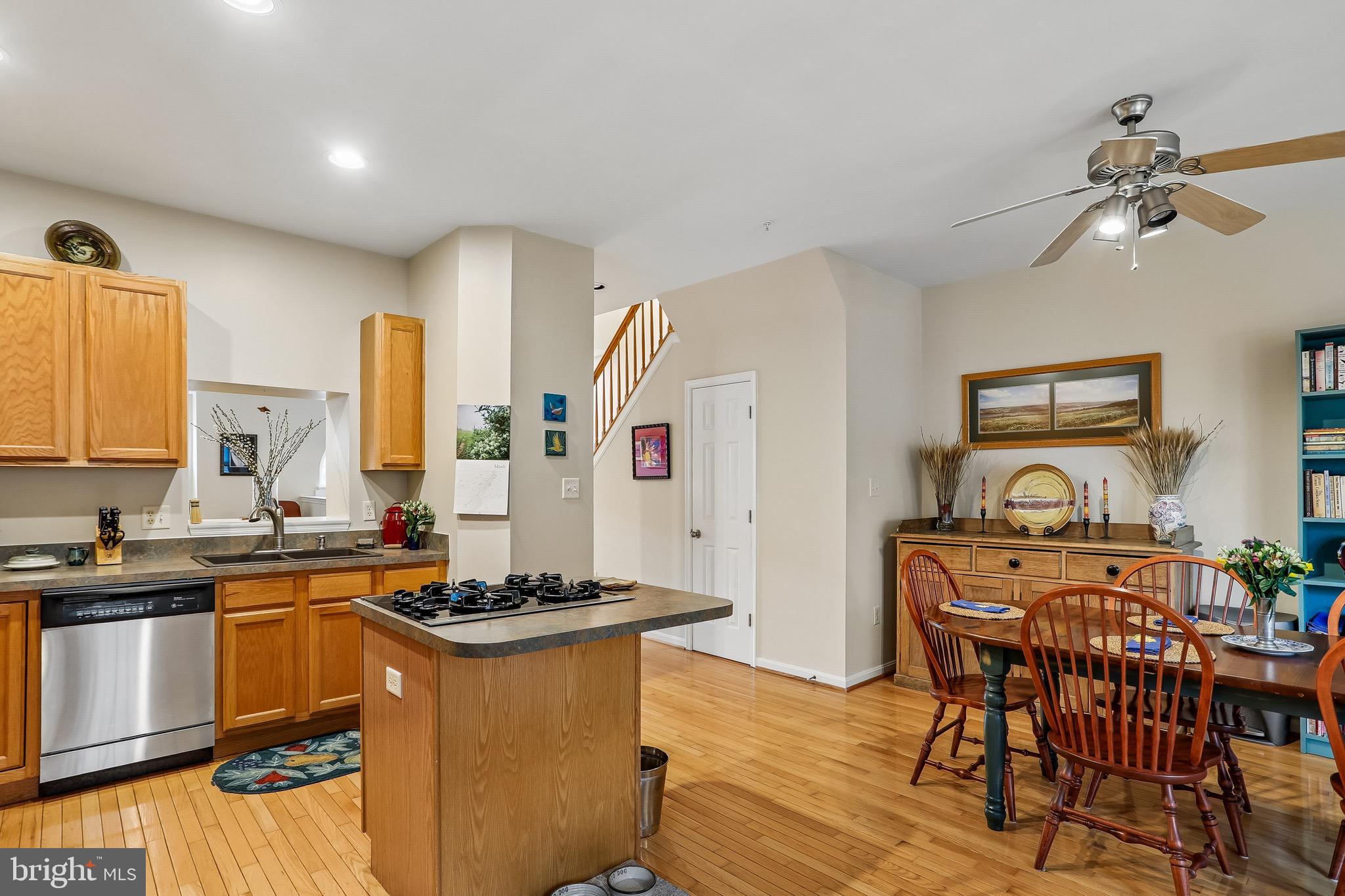 1520 Laurel Wood Way Frederick, MD 21701 - Photo 11 of 30 a kitchen with stainless steel appliances granite countertop a stove a sink dishwasher a dining table and chairs with wooden floor