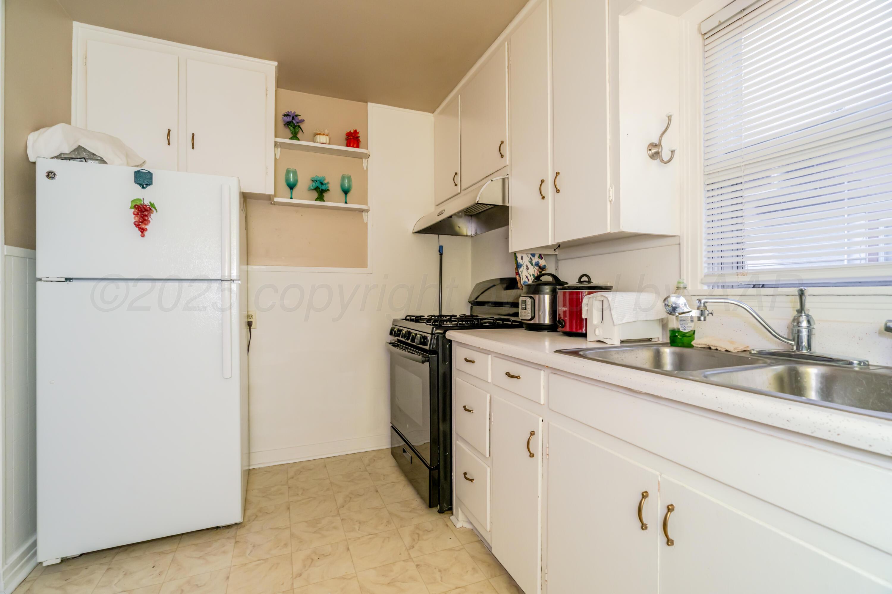 4205 South Jackson Street Amarillo, TX 79110 - Photo 11 of 22 a kitchen with refrigerator and cabinets